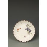 A CHELSEA FLUTED SAUCER, painted in colours with scattered flowers and a butterfly brown line rim,