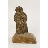 A LEAD FIGURE OF A SCHOLAR OR SAINT holding an open book in his right hand, his left hand open to