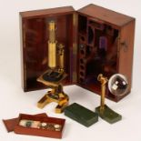 A LACQUERED BRASS MICROSCOPE, by E. Hartnack and Prazmowski, Paris, with a desk magnifier, a