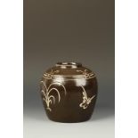 A CHINESE CIZHOU JAR, of rounded form, decorated with a resist design of flowers and butterflys,