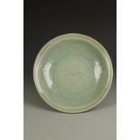A LARGE CHINESE LONGQUAN CELADON DISH, with a broad rim and gently rounded body, the centre