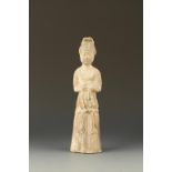 A CHINESE POTTERY FEMALE FIGURE, wearing a long dress tied below the waist with a belt, Tang