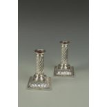 A PAIR OF VICTORIAN TABLE CANDLESTICKS of spiral fluted column form, on swept bases, London 1888, by