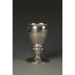 OMAR RAMSDEN: A GOBLET of tapering circular form with a wavy frieze, the stem applied with lions