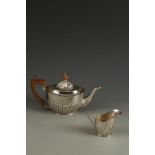 A VICTORIAN PART TEA SET comprising teapot and cream jug of oval form , with part fluted decoration,