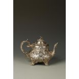 A VICTORIAN TEAPOT of circular bellied form with flower finial and leaf capped scroll handle, the
