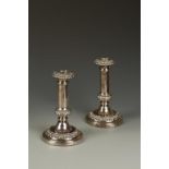 A PAIR OF GEORGE IV CANDLESTICKS with detachable circular sconces and cylindrical stems, with