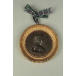A BRONZE METAL PORTRAIT PLAQUE OF NAPOLEON in a gilt metal frame, case with beading and anthemia,