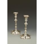 A PAIR OF CANDLESTICKS in the George II style, with shaped square sconces, waisted and knopped