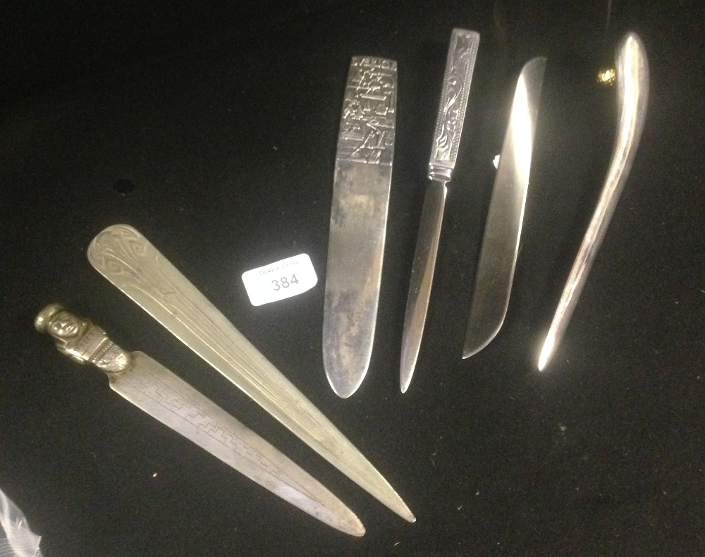 A collection of assorted white metal letter openers