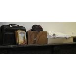 A black leather Gladstone bag, a collection of vintage fancy dress face masks, linen undergarments