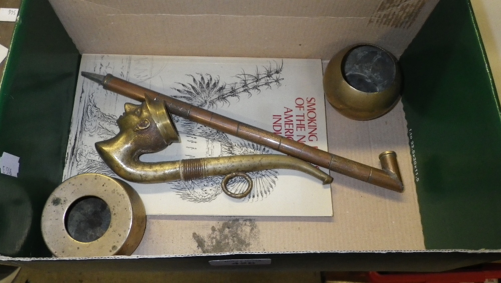 A cast brass pipe of a young man wearing a peaked cap and a collection of similar items