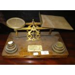 A set of brass postal scales on an oak base