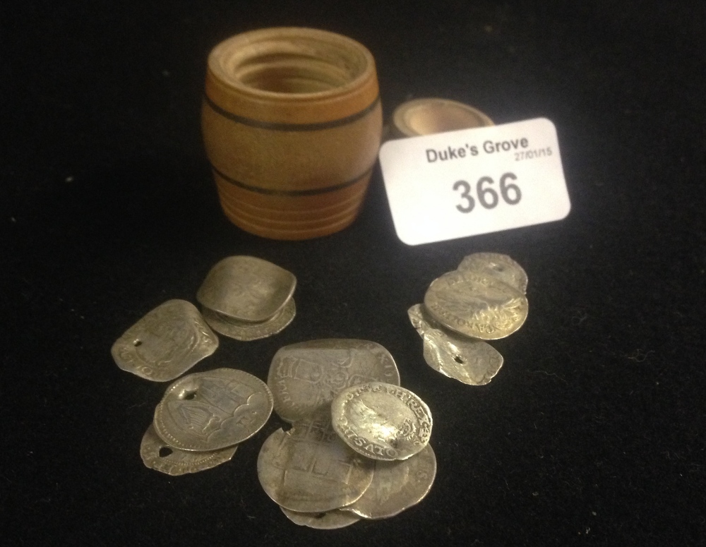 A miniature turned wooden barrel containing a quantity of silver coinage