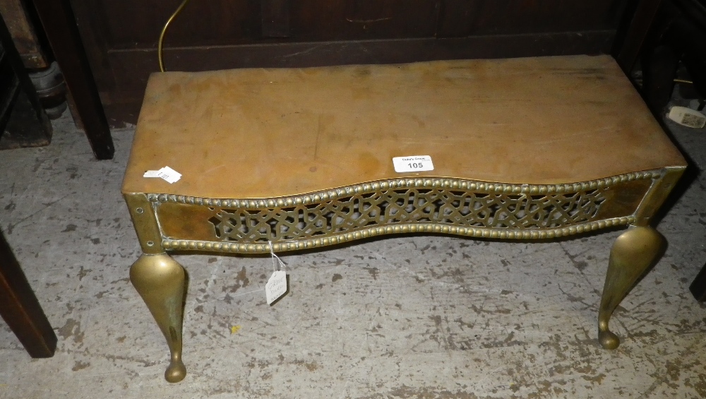 A 19th century brass trivet with a fretwork panel and scroll feet