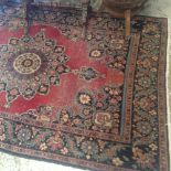 An old Persian design rug, with flower decoration, on red ground within borders of flowers and