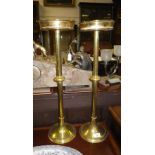 A pair of 19th century brass candlesticks with a tall column on circular feet