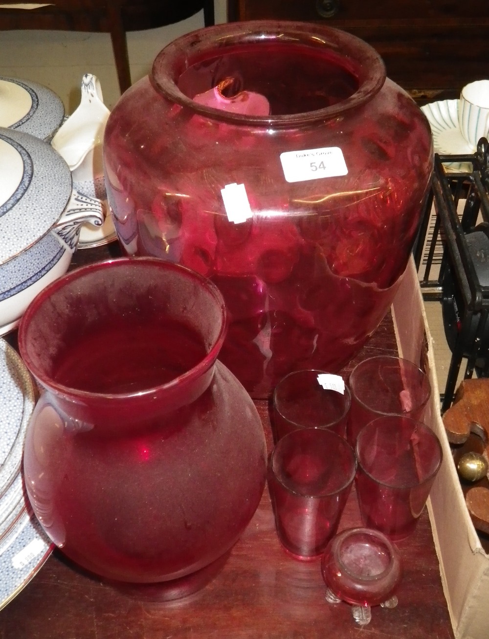 A large cranberry glass shade and similar glassware