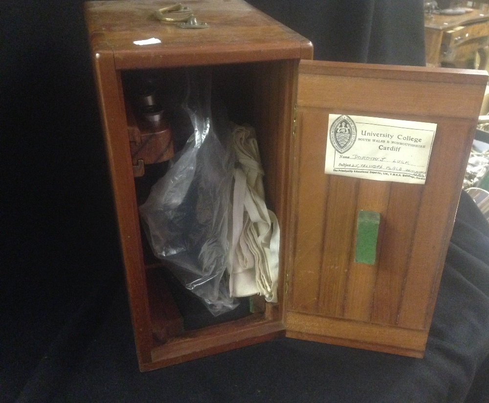 A student's microscope with fitted case with a label 'University College Cardiff'