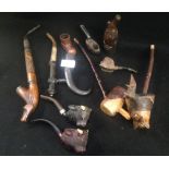 A collection of wooden pipes including two pipes, the bowls carved as bull's heads