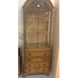 A figured walnut glazed display cabinet, fitted with four small drawers beneath