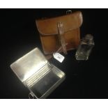 A leather travelling case containing sandwich box and spirit flask