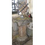 A patinated bronze/brass sun dial on a reconstituted fluted column with acanthus capital