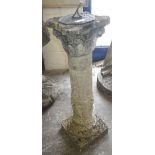 A patinated brass sun dial on a reconstituted stone plinth