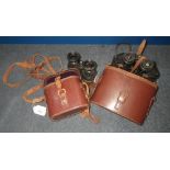 A pair of brass mounted binoculars in leather case and another similar pair