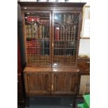 A George III style mahogany collector's cabinet/bookcase, the upper section with glazed doors