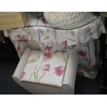 A kidney-shaped dressing table, with floral drapes and matching Lloyd Loom stool