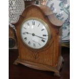 An Edwardian oak cased mantel clock with white enamel dial