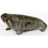 CARVED SOAPSTONE WALRUS, H 5", L 11": having  bone tusks. Signed on the underside and dated  '63'.