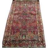 SAROUK PERSIAN WOOL RUG, W 4' 4", L 6' 9": Red  ground with multi-colored designs.