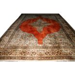 TABRIZ WOOL CARPET, W 12' 5", L 17' 10": Having  a central medallion in a rust colored ground.