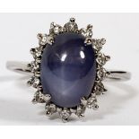 14 KT WHITE GOLD, SAPPHIRE AND DIAMOND RING:  White gold. Natural star sapphire surrounded by