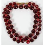 VALENTINO RED BEAD NECKLACE, L 36 1/2": Dark  red translucent beads of graduated size.  Labeled: "V"