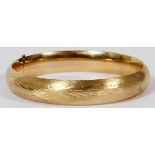 14KT YELLOW GOLD HINGED BRACELET: A hinged 14kt yellow gold bangle bracelet with brushed finish.