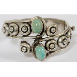 MEXICAN STERLING & TURQUOISE BANGLE BRACELET: A hinged sterling silver bangle bracelet set with