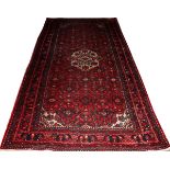 DERGAZINE PERSIAN WOOL RUG, 11' 0" X 5' 8": Red ground, central medallion and overall multi-