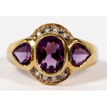 14KT YELLOW GOLD, AMETHYST, & DIAMOND RING: With an oval amethyst flanked by two heart shapes.