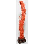 CHINESE CARVED ANGEL SKIN CORAL FIGURE OF GUANYIN, H 9": Carved standing figure holding a fan,