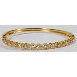 1.37CT DIAMOND & 14KT GOLD LADY'S BANGLE BRACELET: A 14kt yellow gold lady's bangle bracelet,