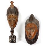 AFRICAN CARVED MASKS, TWO, H 14" & 19 1/4":  One  having a carved female figure at the base.