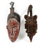 AFRICAN CARVED MASKS, TWO, H 16" & 17":  One  with carved geometric shapes around the border,  and