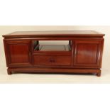 Oriental hardwood sideboard fitted with two doors, a drawer and a pull out shelf, 137cm long x