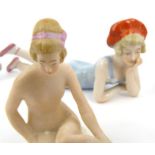 Two novelty Edwardian bisque nude bathing ladies - one with an orange bathing hat, a bisque piano