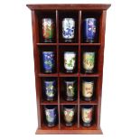 Set of twelve oriental metal cloisonné beakers with hardwood stands and display case, each 9cm