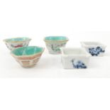 Three Oriental Chinese porcelain tea bowls hand decorated with fish and signs, and a pair of blue