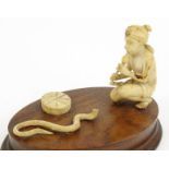 Carved ivory model of an Indian snake charmer mounted on a wooden base, 10cm high : For Condition